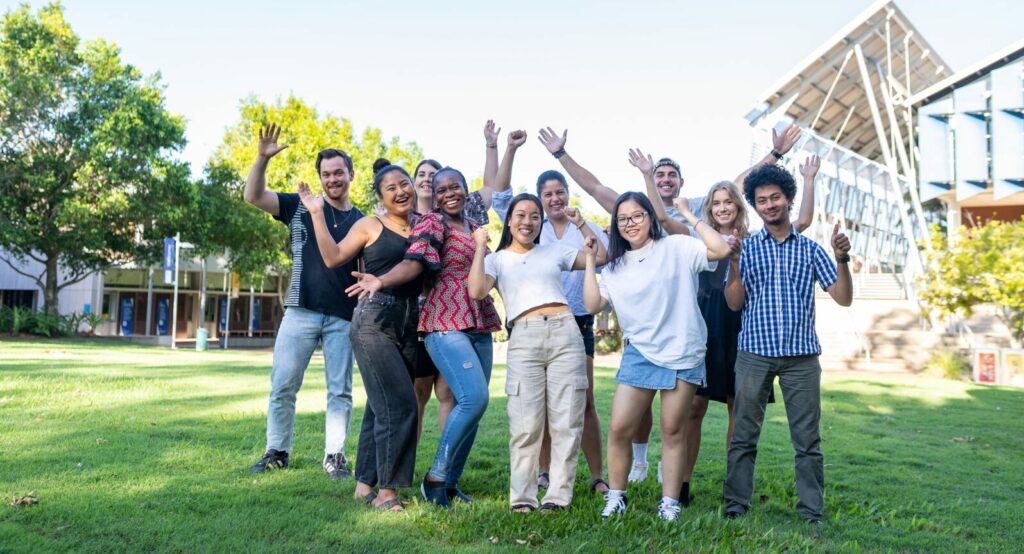 glada studenter på campusets gräsmatta